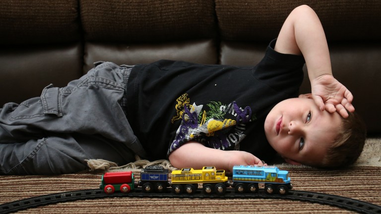 Joshua Sekerak takes a break from playing with his train at his home