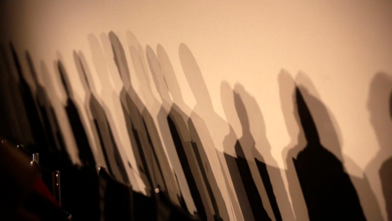 Shadows of members of a panel are seen on a wall