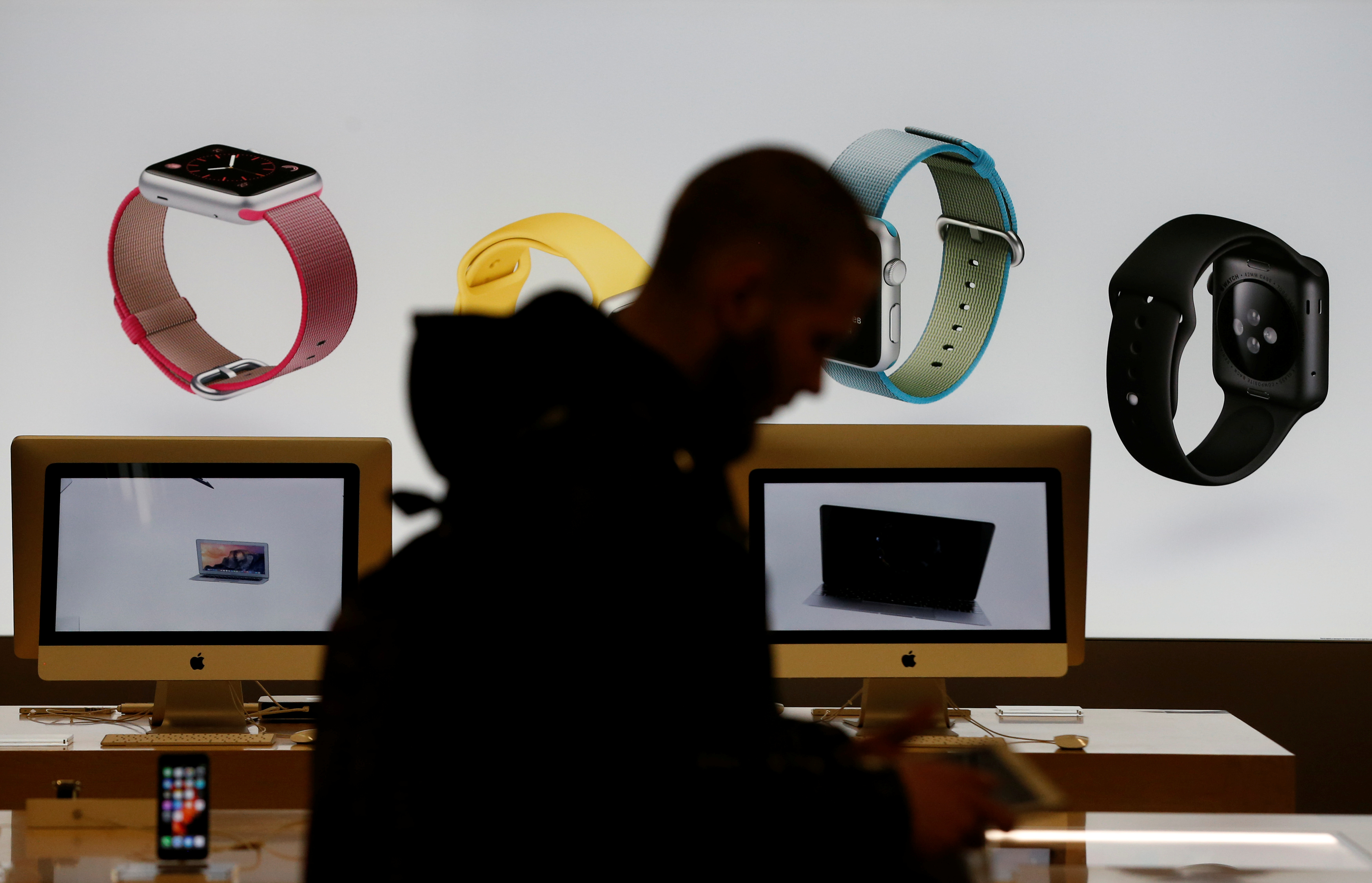 A customer walks past a screen displaying an advertisement of Apple iWatch in a store of Russia's biggest electrical and white goods retailer M.video in Moscow, Russia, April 15, 2016