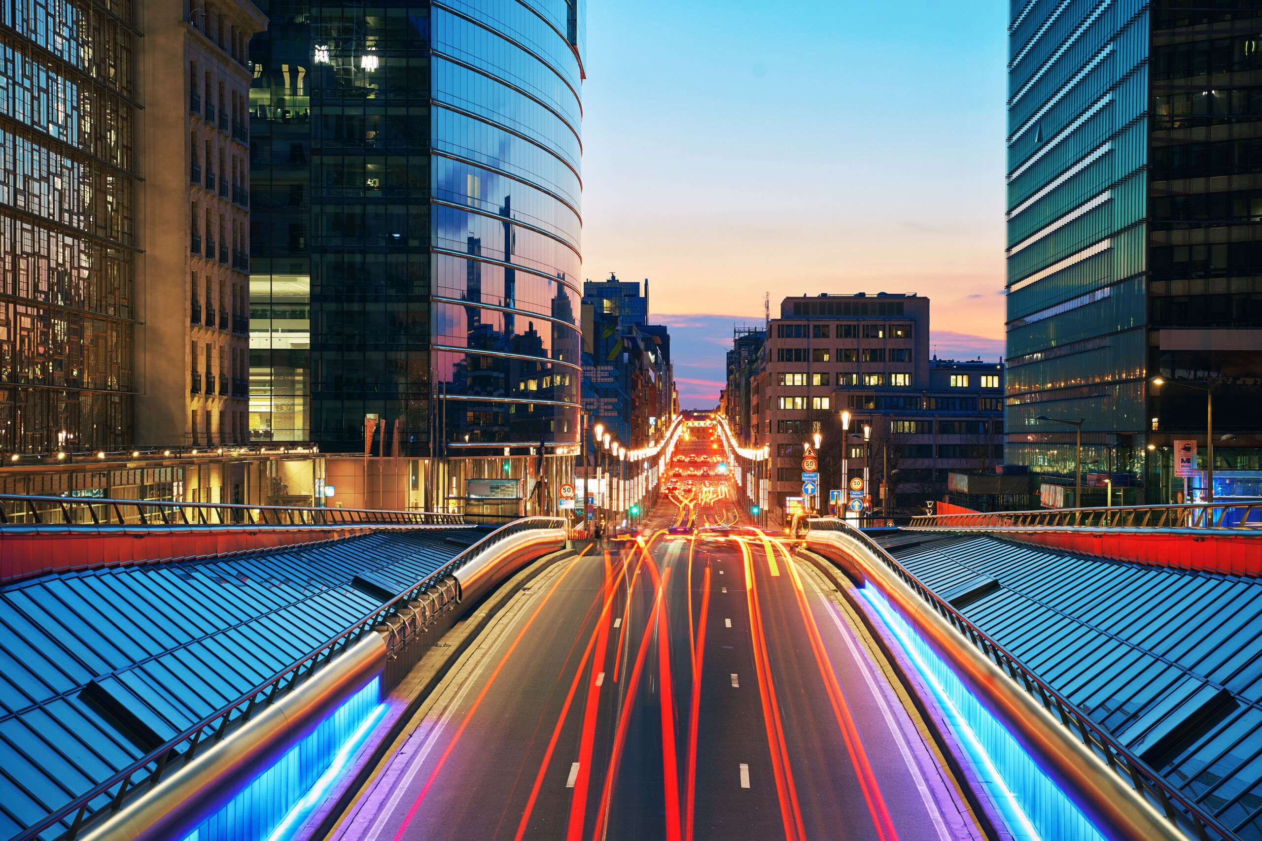 Long shot of downtown street at sunset. Skyscrapers on with traffic lights. Brussels, Belgium. - Thomson Reuters Institute