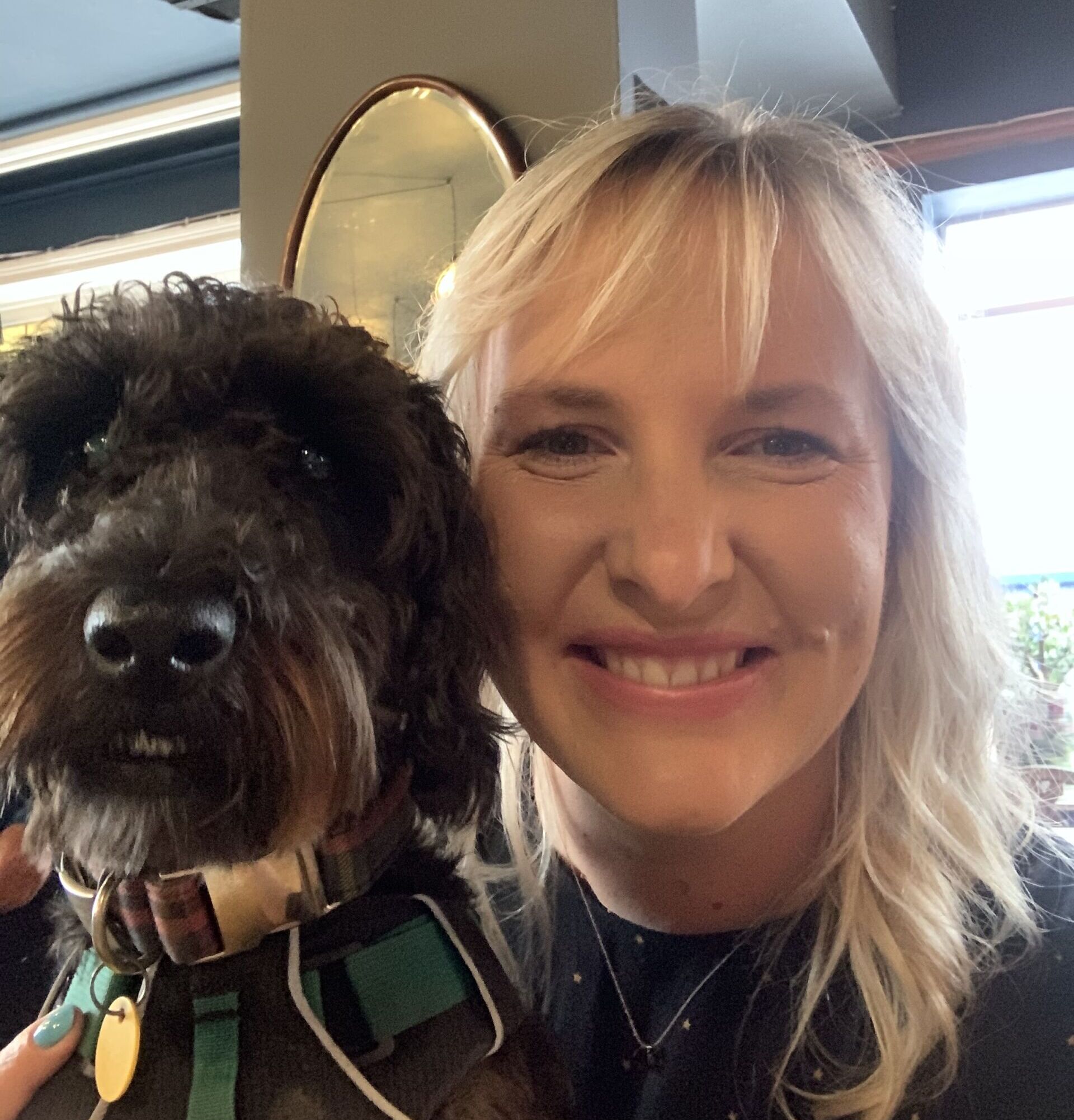 Nicole and her dog smiling while taking a selfie together. 