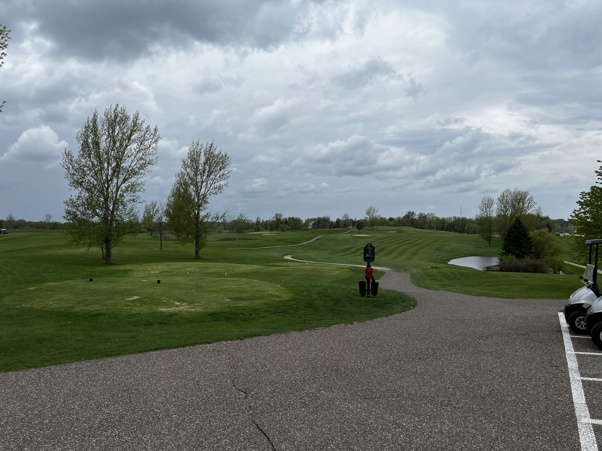 A golf course with bright green grass and a dark blue sky. 