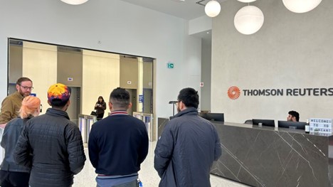 Five people stand with their backs to the camera in the lobby of our Toronto office.