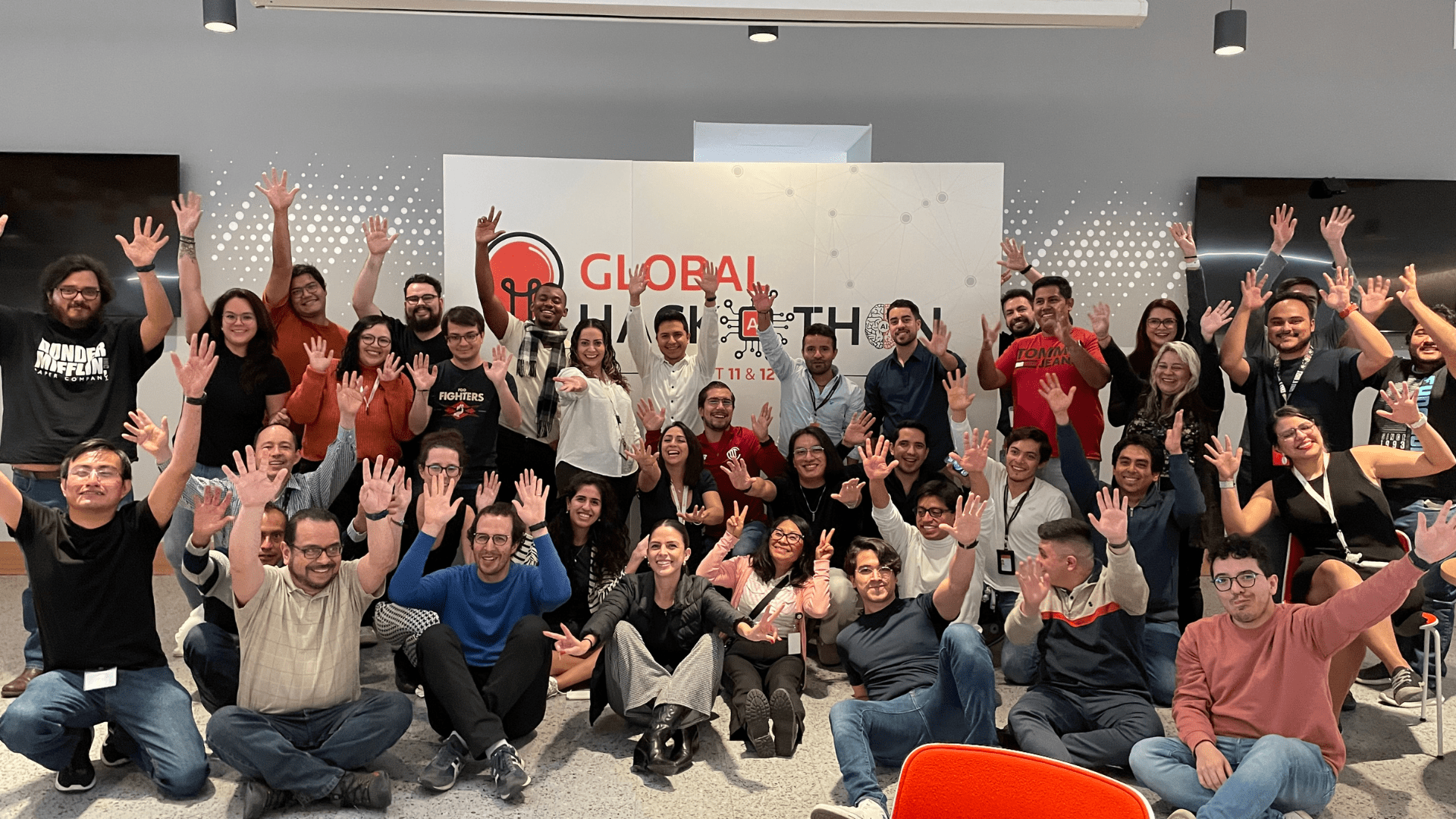 A large group of teammates pose for a photo together during the Global AI hackathon.