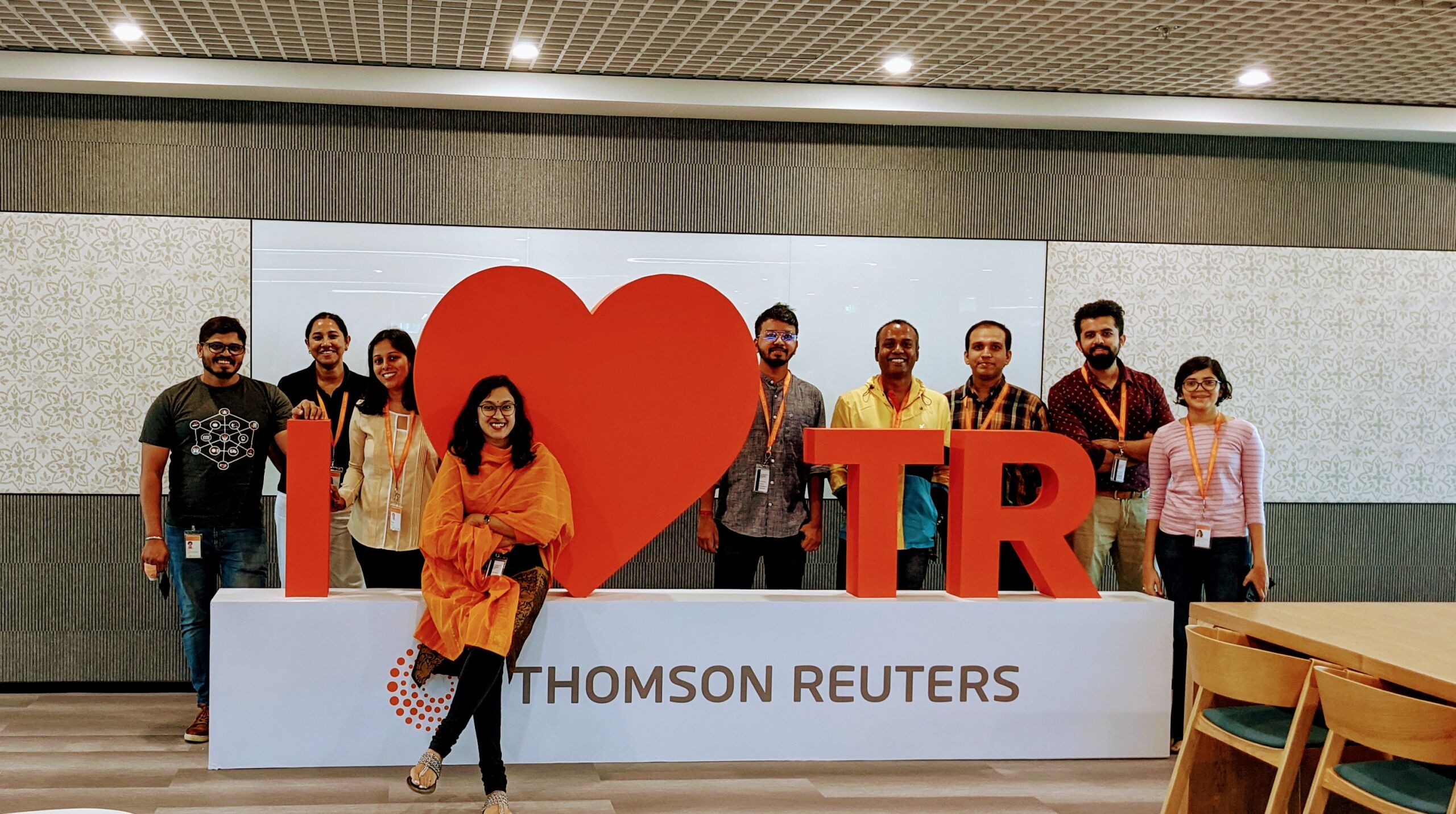 Shirsha and her team standing in front of a sign reading 'I heart TR' inside our Hyderabad office.