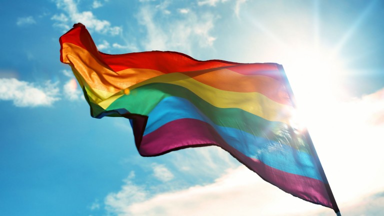 Gay pride flag on sky background